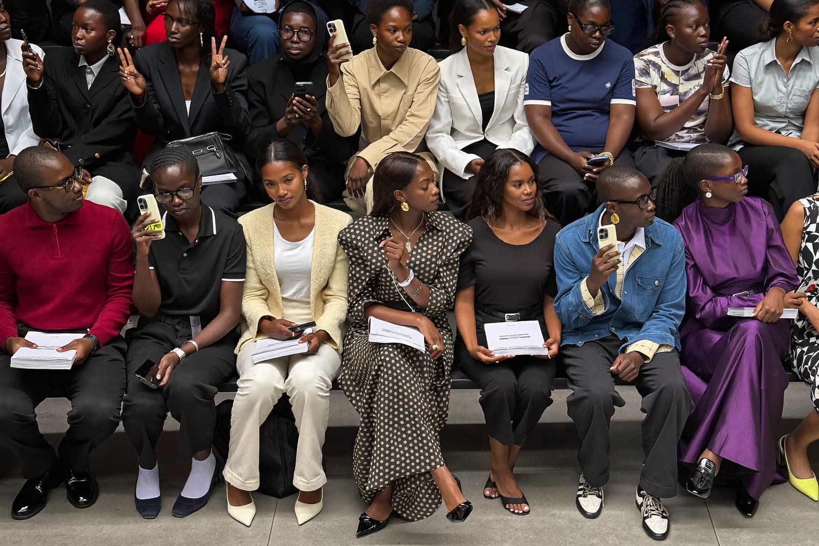Front row guests raise their phones as a show begins